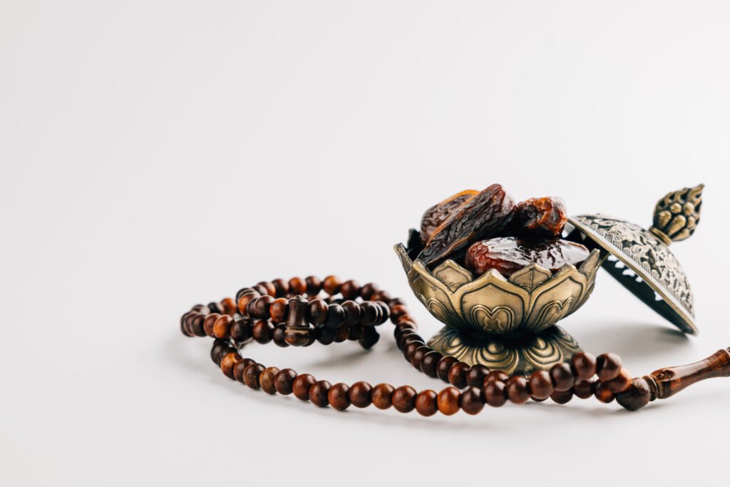 Holy Ramadan Celebration With Dates In Ornate Dish And Prayer Beads On A Simple White Background